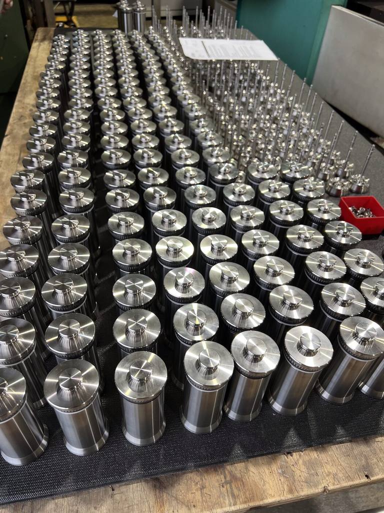 Hundreds of machined components across the workshop bench